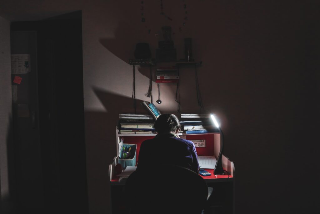 コンピューターを使用して椅子に座っている黒いシャツを着た男